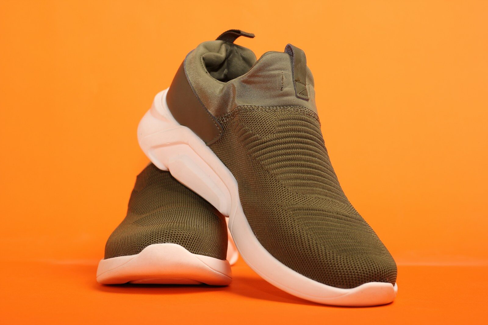 a pair of sneakers on an orange background